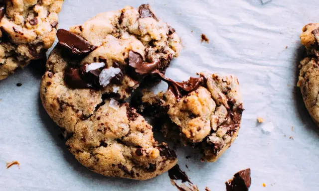 Des cookies aux pépites de chocolat fondantes, parfaits pour apprendre comment faire des cookies maison. Le chocolat coule, invitant à la dégustation.