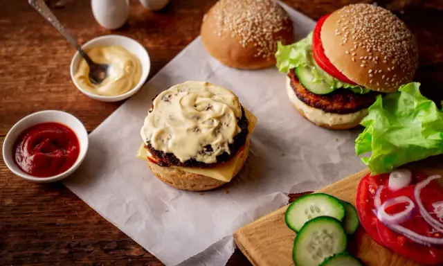 Pyszny burger z bogatym sosem do burgera, ketchupem i świeżymi dodatkami.