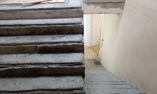 Surowe schody betonowe czekają na malowanie lastryko. Trwa remont klatki schodowej.