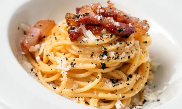 Pyszna carbonara z chrupiącym boczkiem, posypana parmezanem i pieprzem. Idealny boczek do carbonary to klucz do sukcesu.