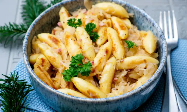 Herzhafte Schupfnudeln mit Sauerkraut, garniert mit Petersilie. Ein Klassiker, der auf keinem Tisch fehlen darf.