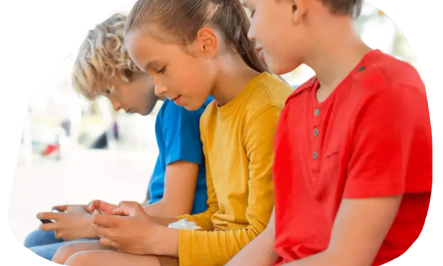Trois enfants, dont mon fils, sont absorbés par leurs écrans.