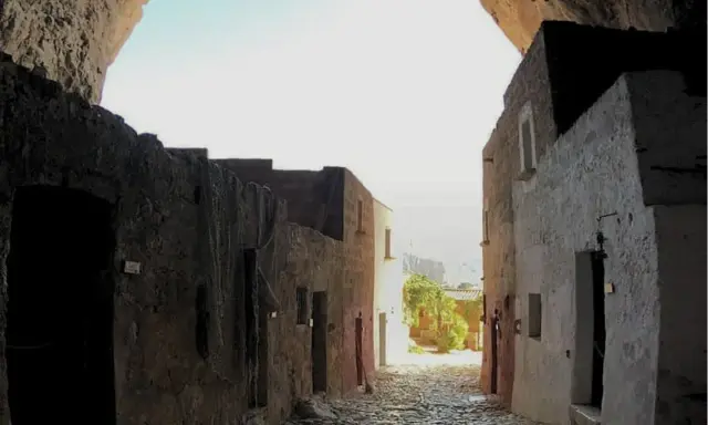 Antica via acciottolata che conduce verso il mare, incastonata nella roccia della grotta Mangiapan.