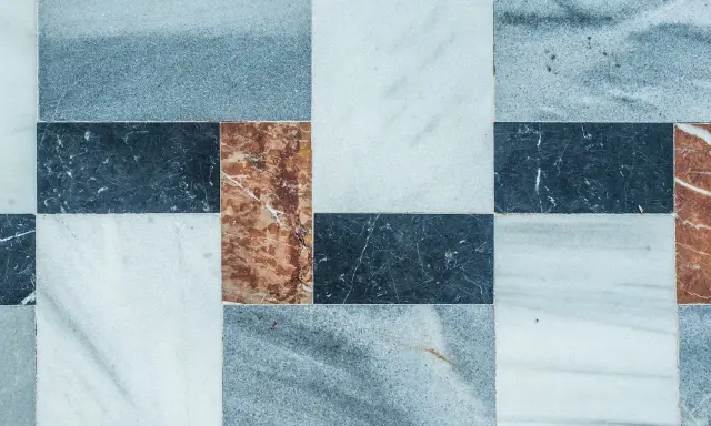 Wzór płytek marmurowych z widocznymi drobnymi rysami, sugerujący usuwanie rys z płytek szkliwionych.