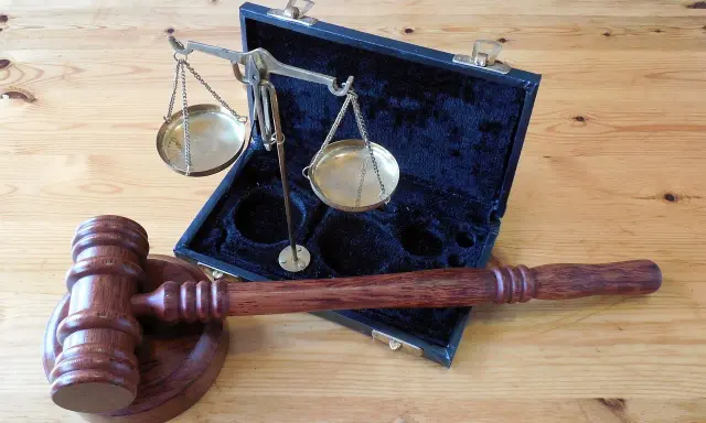 Młotek sędziowski i waga szalkowa w futerale. Symbol sprawiedliwości, który może pomóc zrozumieć, jak liczyć wyrok łączny.
