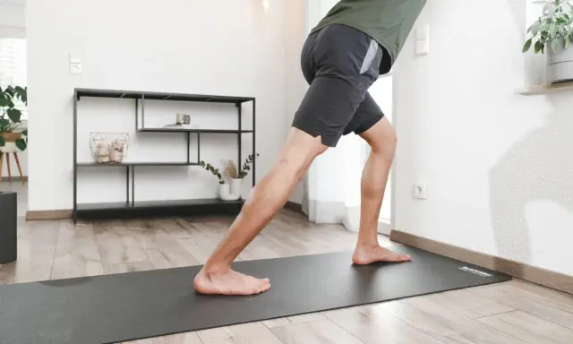 Mann dehnt seine Waden an der Wand, um die Muskeln zu lockern.