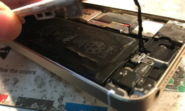 Naprawa iPhone po zalaniu. Widoczna otwarta obudowa, bateria Li-ion i elementy wewnętrzne.