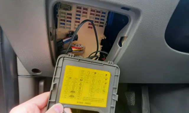 Wnętrze samochodu z otwartą skrzynką bezpieczników. Na klapce schemat, w tym oznaczenie dla navitel smart box max.