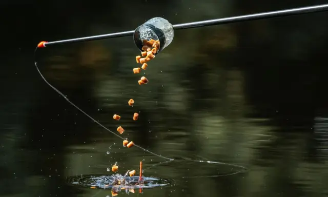 Zanęta do method feeder spada do wody, tworząc idealną chmurę przyciągającą ryby.