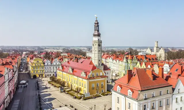 Rynek w Bolesławcu z ratuszem i wieżą zegarową. Kolorowe kamienice i brukowany plac tworzą urokliwe bolesławiec atrakcje.