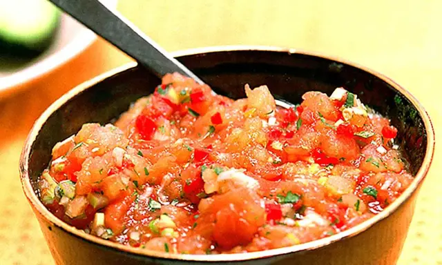 En skål med färsk pico de gallo, en klassisk mexikansk salsa med hackade tomater, lök och koriander. Perfekt till tacos!