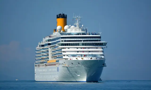 La nave da crociera Costa Luminosa solca il mare calmo sotto un cielo azzurro.