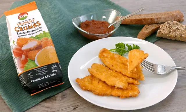 Escalope de pollo crujiente, listo para disfrutar. Acompañado de pan y salsa.