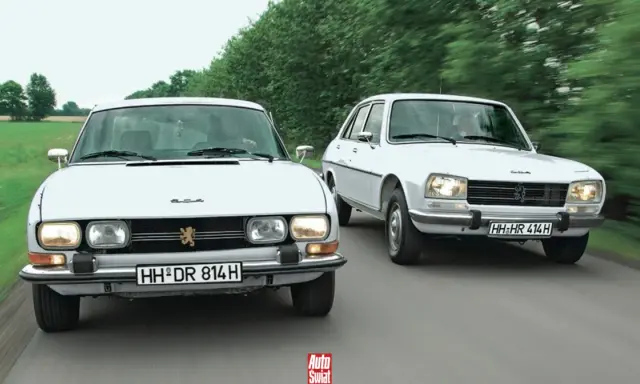 Dwa białe Peugeot 504 jadące obok siebie po wiejskiej drodze.