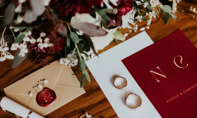 Eleganckie zaproszenie na wesele 2 tygodnie przed, z monogramem pary, obrączkami i bukietem.