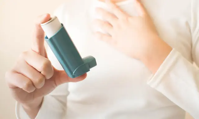 Person hält einen Inhalator, ein wichtiges saba Medikament, um Atemnot zu lindern.