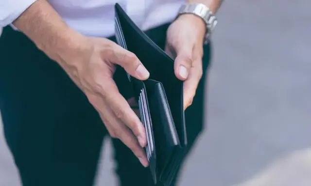 Puste ręce trzymające portfel, symbolizujące trudności finansowe i przykłady stagflacji.