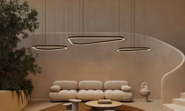 Un salon moderne avec un plafond cathédrale, des suspensions lumineuses organiques, un canapé moelleux et un escalier incurvé.