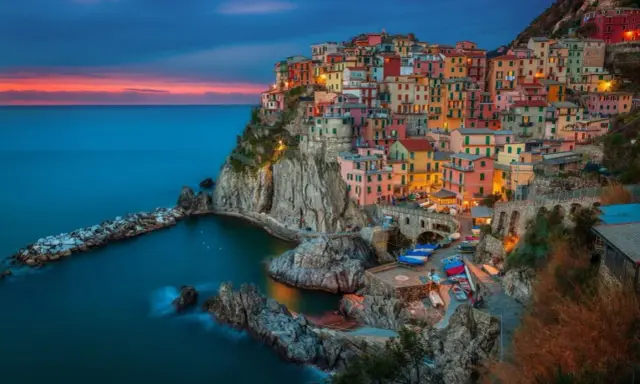 Kolorowe domy Cinque Terre nad turkusowym morzem. Idealne miejsce, gdzie do Włoch na wakacje.