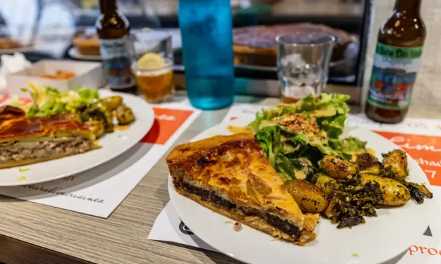 Tranche de pâté en croûte, spécialité Limoges, servie avec salade et pommes de terre rôties.
