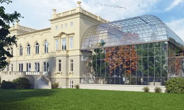 Elegancka willa z oranżerią, prawdopodobnie najdroższy hotel w Łodzi, otoczona zielonym trawnikiem.