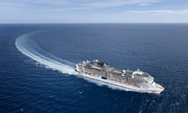 La MSC Virtuosa, con la sua impressionante lunghezza, solca le acque blu lasciando una scia bianca.