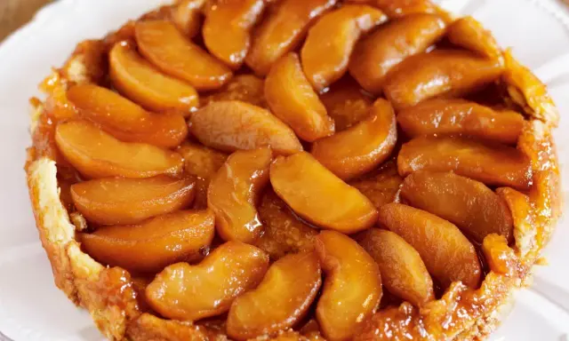 En gyllene tarte tatin med karamelliserade äppelklyftor som glänser. En klassisk fransk dessert som smälter i munnen.