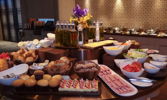 Ideas para buffet desayuno hotel: croissants, pasteles de fresa, jamón, ensaladas, frutas y panes.
