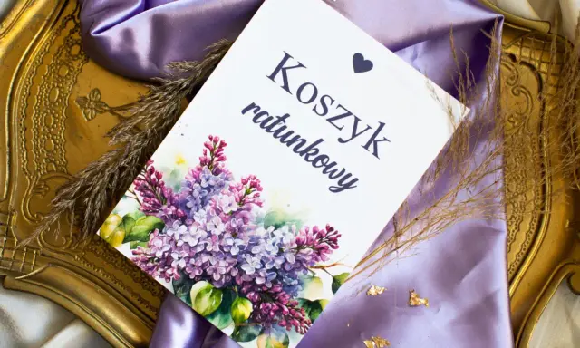 Eleganckie elementy zaproszenia: kartka z napisem "Koszyk ratunkowy", ozdobiona bukietem bzu, na tle fioletowej satyny i złotej ramki.