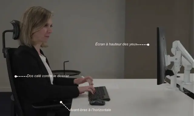 Une femme assise, respectant la règle ergonomique : dos calé, avant-bras à l'horizontale, écran à hauteur des yeux.