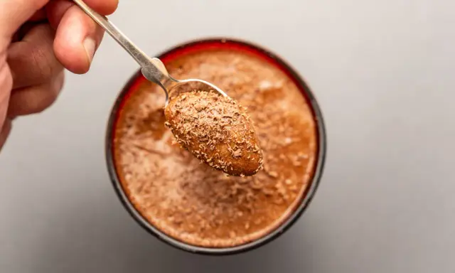 Ein Löffel mit Schokostückchen auf einer cremigen Mousse au Chocolat. Das Originalrezept für puren Genuss.