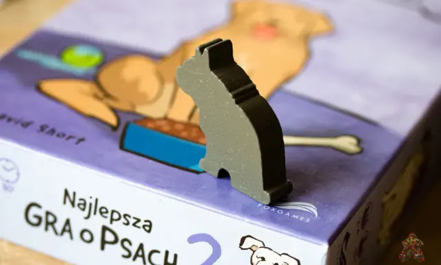 Szary kotek na pudełku gry planszowej "Najlepsza gra o psach". Czas na wspólną grę z pieskami!