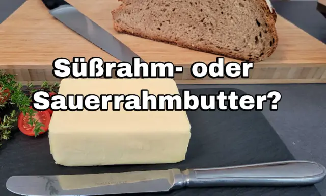 Ein Block Butter liegt neben Brot und Kräutern. Die Frage: Süßrahm- oder Sauermilchbutter?