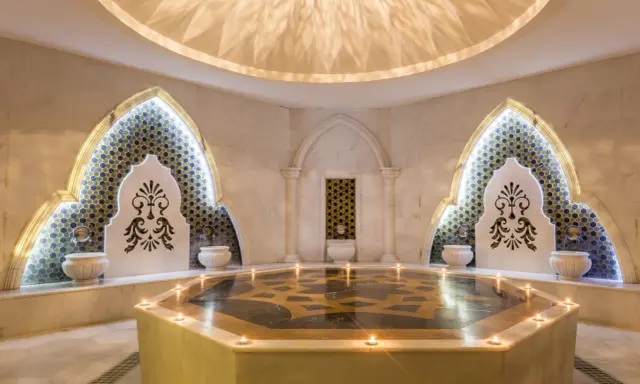 Luxuriöses Hamam Dampfbad mit Marmor, Mosaiken und Kerzenlicht.