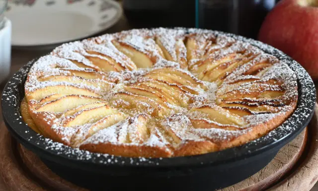 Torta di mele in friggitrice ad aria, dorata e cosparsa di zucchero a velo, pronta per essere gustata.