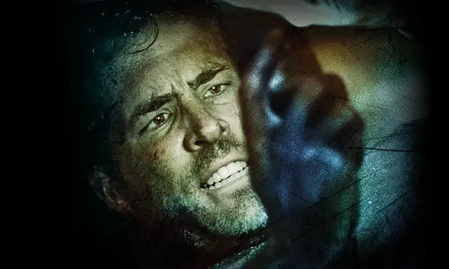 Ryan Reynolds i en intensiv scen från en av hans filmer. Ansiktet är svettigt och han ser ut att vara i fara.