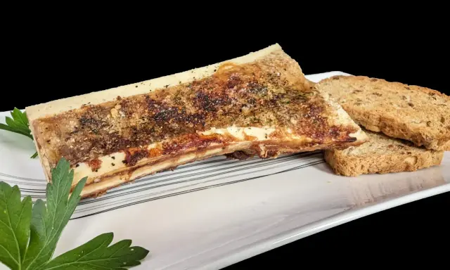 Os à moelle rôti, assaisonné d'herbes et de poivre, servi avec des toasts croustillants. Une recette os à moelle gastronomique à savourer.