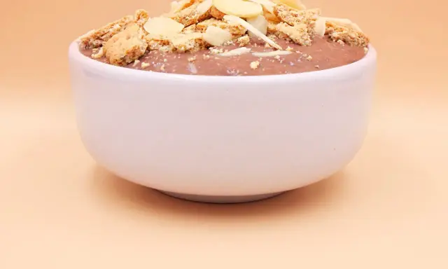 Czekoladowy pudding proteinowy z płatkami migdałów i pokruszonymi ciasteczkami. Czy pudding proteinowy jest zdrowy? To zależy od składników!