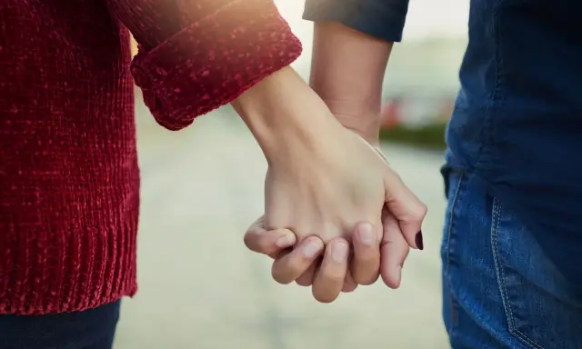 Mani che si stringono, simbolo del significato dell'ancora in amore: stabilità, sicurezza e un legame profondo che resiste alle tempeste.