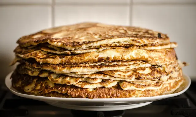 Pile généreuse de crêpes à la farine de châtaigne, dorées et appétissantes, prêtes à être dégustées.