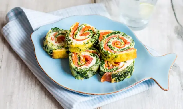 Rouladen mit Lachs und Spinat auf einem Fisch-Teller. Leckere Morbus Crohn Rezepte, die gut verträglich sind.
