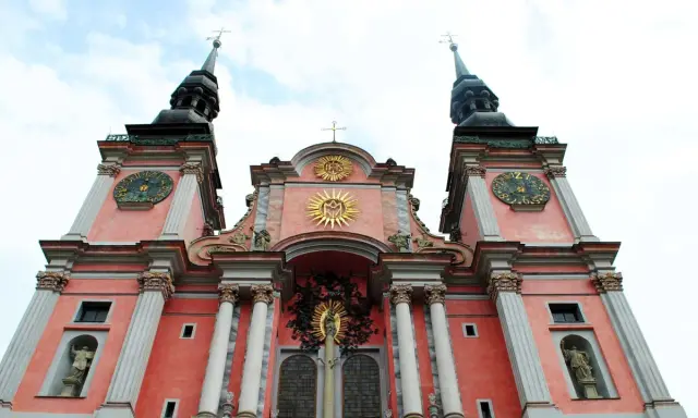 Święta Lipka: barokowa bazylika z zegarami na wieżach i złotymi symbolami religijnymi. Atrakcje tego miejsca przyciągają turystów.