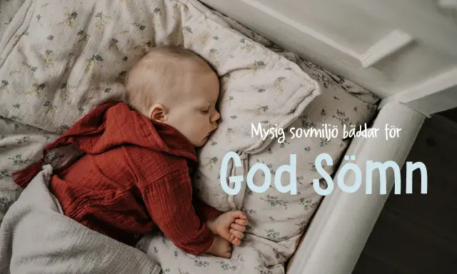 Sött barn sover i spjälsäng, inbäddat i mjukt tyg med blommor. En mysig sovplats som bäddar för god sömn.