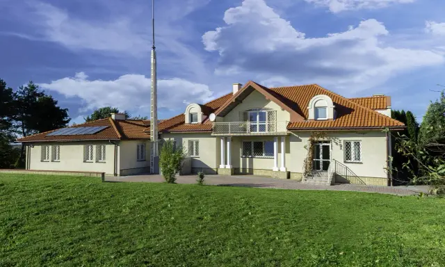 Nowy początek w ośrodku terapii uzależnień i depresji. Dom z czerwonym dachem, otoczony zielenią, zaprasza do spokoju i regeneracji.