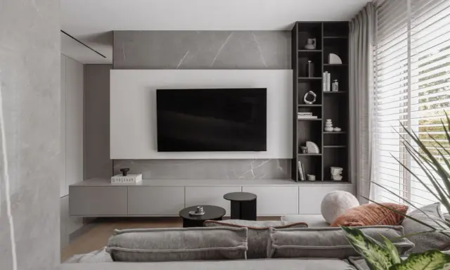Nowoczesne pomysły na ścianę TV: minimalistyczna zabudowa, szary marmur i elegancka półka.