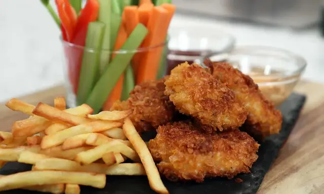 Krispiga chicken nuggets med pommes frites och grönsaksstavar. Perfekt för en mysig kväll!