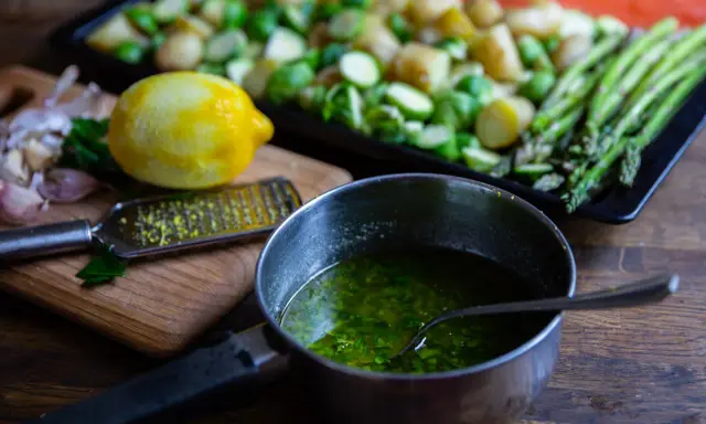 Förberedelser för allt på en plåt lax: färsk lax, potatis, brysselkål, sparris, citron och vitlök.