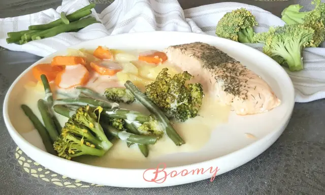 Filet de saumon avec un assortiment de légumes verts, carottes et pommes de terre en sauce crémeuse. Un plat savoureux et coloré.