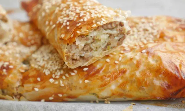 Krispig filodegsrulle fylld med köttfärs och lök, toppad med sesamfrön. Ett perfekt filodeg recept för en god måltid.