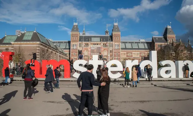 Ludzie pozują przy wielkich literach "I amsterdam" przed Rijksmuseum. Idealne miejsce na pamiątkowe zdjęcie z weekendu w Amsterdamie.